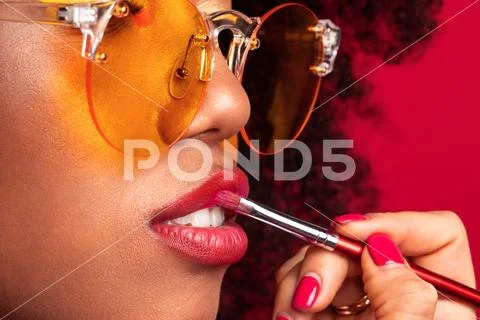 Makeup artist with a brush paints the lips Stock Photos