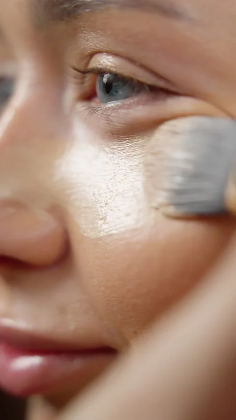 Makeup artist carefully applying liquid foundation with professional brush Stock Footage 304331892