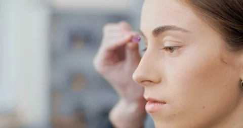 Makeup artist combs eyebrow models with a brush Stock Footage 126181562