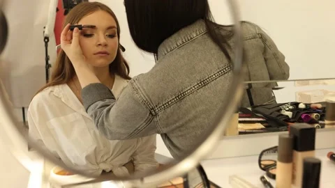 Makeup artist combs eyebrow models with a brush, make up process in slow motion Stock Footage 162348364