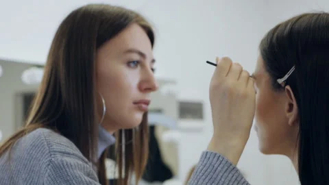 Makeup artist combs the model's eyebrows. Close-up face of beautiful female 스톡 동영상 167283668