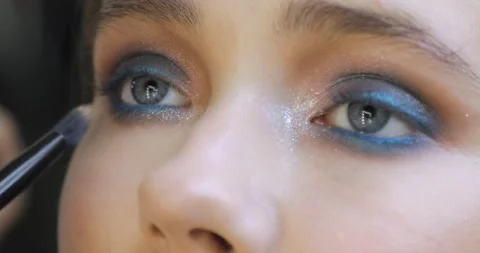 Makeup artist is correcting makeup under the eyes on woman's face, eyes closeup. Stock Footage 145502759