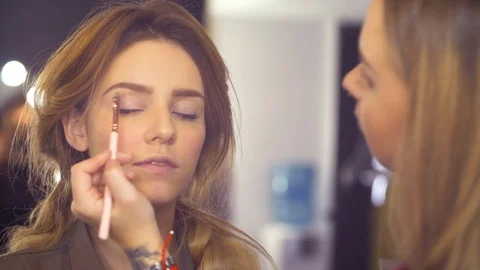 The makeup artist correcting the shape of eyebrow Stock Footage 88711796