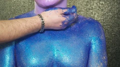 Makeup artist is covering man's face with the sparkles Stock Footage 74078490