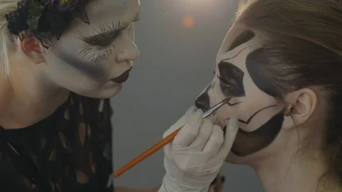 Makeup artist creates make-up on the face, preparing for the halloween party Stock Footage 117704544
