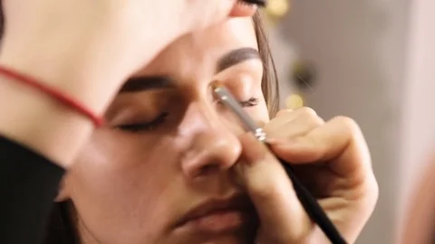 Makeup artist creates the shape of the eyebrows for the model Stock Footage 84988954