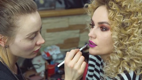 Makeup artist creating beautiful makeup for blonde model Stock Footage 76060548