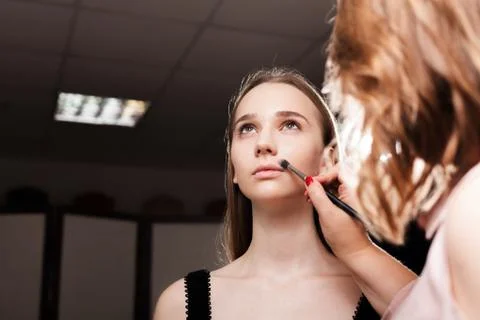 Makeup artist dabbing foundation on a client Stock Photos
