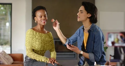 Makeup artist dipping brush sweeping blush on client cheek and showcasing it Stock Footage 344325824