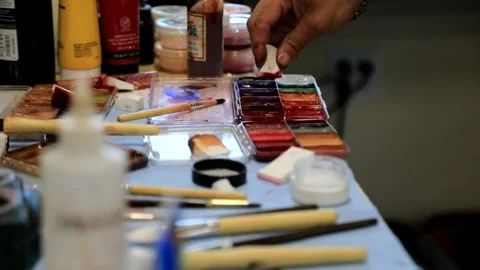 Makeup artist dipping sponge into tray of paints Stock Footage 202073489