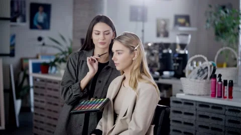 The makeup artist discusses with the client the future makeup, choose eye Stock Footage 236399734