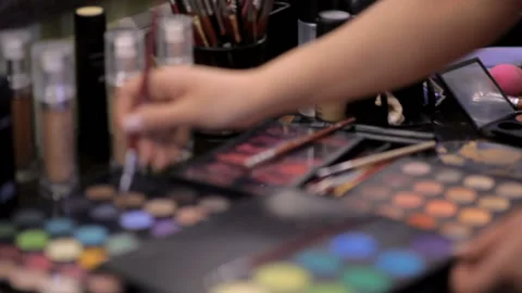 Makeup artist does makeup to a client in a beauty salon with a lot of beautiful Stock Footage 115050160