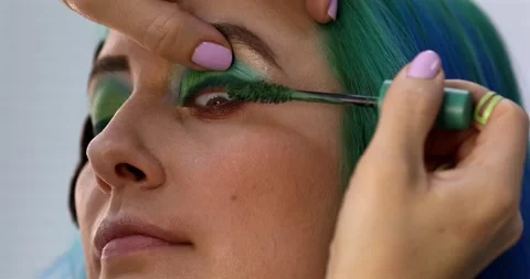 Makeup artist doing make-up for young woman, applying black mascara. Stock Footage 305232761