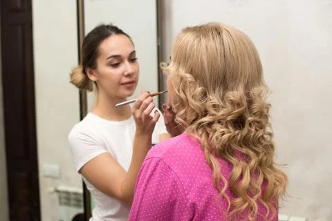 The makeup artist doing a makeup for bride Stock Photos