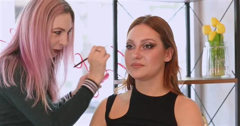 Makeup artist doing professional make up of young woman. Stock Footage 311222202