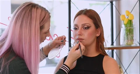 Makeup artist doing professional make up of young woman. Stock Footage 311222211