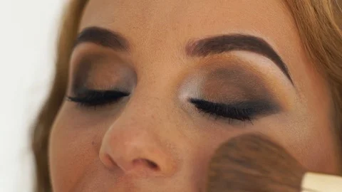 Makeup artist doing stylish makeup to fashion model. Close up visagiste using Stock Footage 91651050