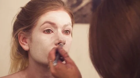 Makeup artist drawing on the model's face 스톡 동영상 83243833