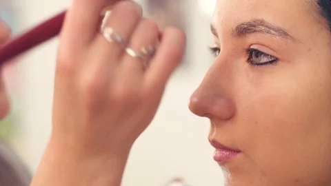 Makeup artist drawing on the model's face Video stock 88717951