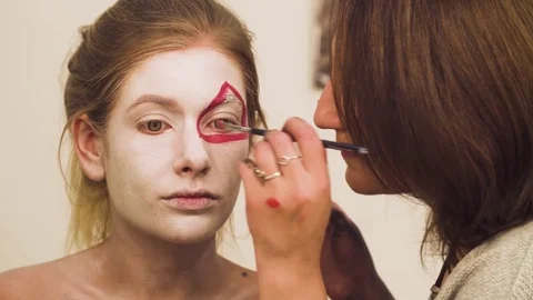 Makeup artist drawing red lines on the face Video stock 83337758
