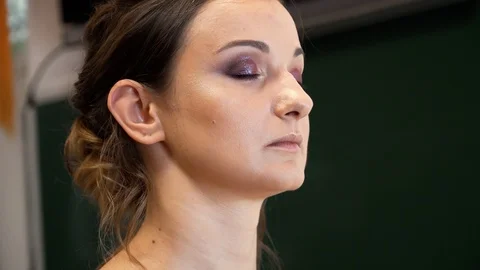 A makeup artist draws a beautiful model's eye with a bright shining eye shadows 動画素材 127501535