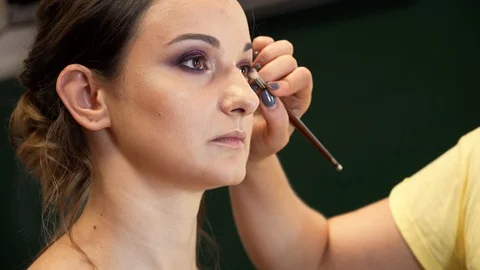 A makeup artist draws a beautiful model's eye with a bright shining eye shadows 動画素材 127501575