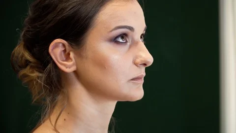 A makeup artist draws a beautiful model's eye with a bright shining eye shadows 動画素材 127501786