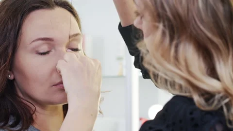 Makeup artist draws the shape of a woman's eyebrows in a beauty salon. Cosmet Stock Footage 162513680