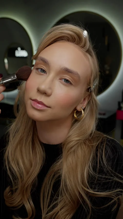Makeup artist gently applying blush to a young woman's cheeks. Makeup Artist Stock Footage 263839018