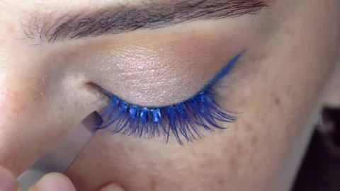 Makeup artist glues on false blue eyelashes. Video of eyelash extension. Stock Footage 343800531