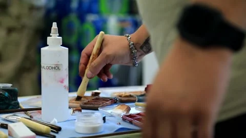 Makeup artist loading brush with paint to create simulated wound Video stock 202073490