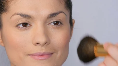 Makeup artist makes a beautiful makeup to a girl. Face of a beautiful girl close Stock Footage 77328224