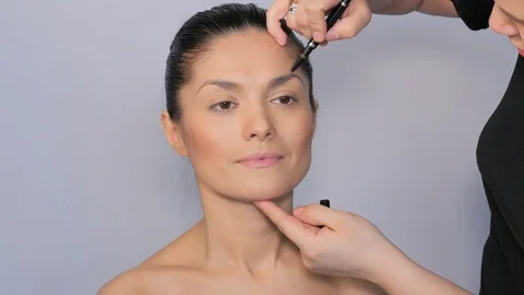 Makeup artist makes a beautiful makeup to a girl. Stock Footage 77329773