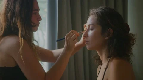 A makeup artist makes a bright makeup for a beautiful girl model Stock Footage 150508544