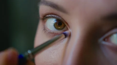 A makeup artist makes a bright makeup for a beautiful girl model Stock Footage 150562635