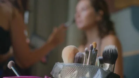 A makeup artist makes a bright makeup for a beautiful girl model Stock Footage 150572572