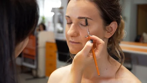 A makeup artist makes a contour of the eyebrows with a brush 動画素材 127501316