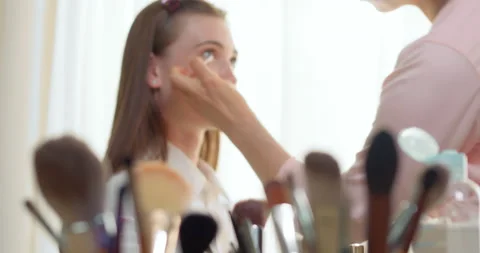 Makeup artist makes face makeup to beautiful young woman model. Stock Footage 208867189