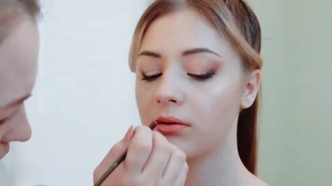 Makeup artist makes lips makeup for a beautiful girl close-up. Stock Footage 149686994