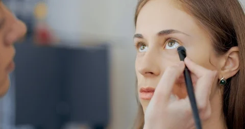 Makeup artist makes makeup to young girl and sinks bags under model eyes Video stock 126129453