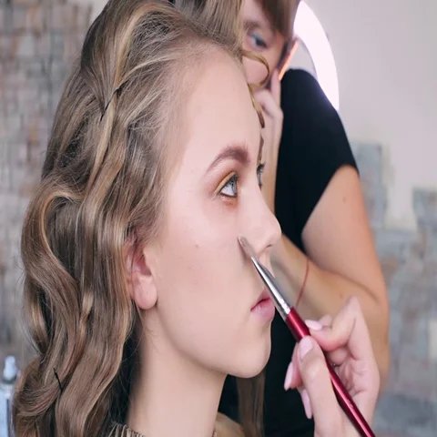 Makeup artist makes models eye makeup. Hairdresser makes hairstyle for model Stock Footage 69546293