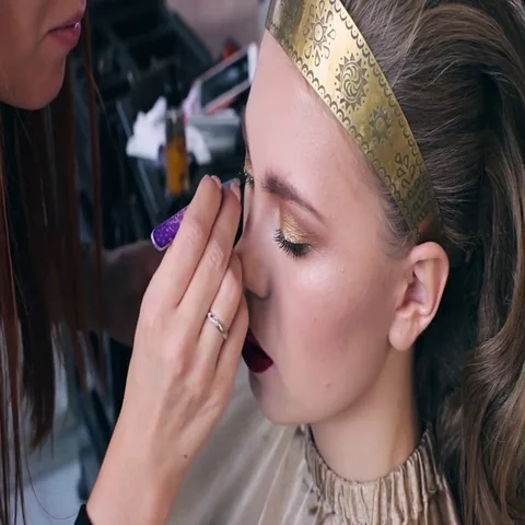 Makeup artist makes models eye makeup. Hairdresser makes hairstyle for model Stock Footage 69547145
