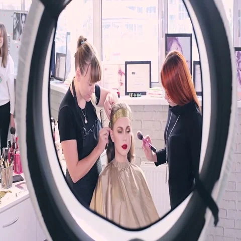 Makeup artist makes models eye makeup. Hairdresser makes hairstyle for model Stock Footage 69547282
