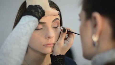 Makeup artist makes models eye makeup Stock Footage 70663021