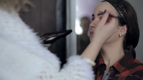 Makeup artist makes models eye makeup Stock Footage 73511609