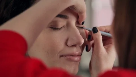 Makeup artist makes models eye makeup Stock Footage 73578081