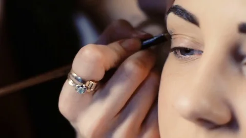 Makeup artist makes models eye makeup Stock Footage 83409040
