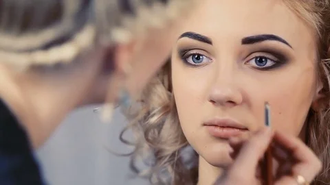 Makeup artist makes models eye makeup Stockbeeldmateriaal 83409408