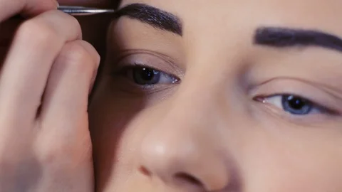 Makeup artist makes models eyebrows makeup Stock Footage 90905900