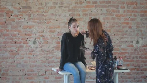 Makeup artist makes wax plastic makeup for art cinema and paints face of girl Video stock 105599711
